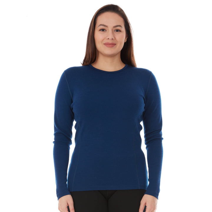 A woman models a soft, 100% merino wool, midweight base layer crew top. The women&