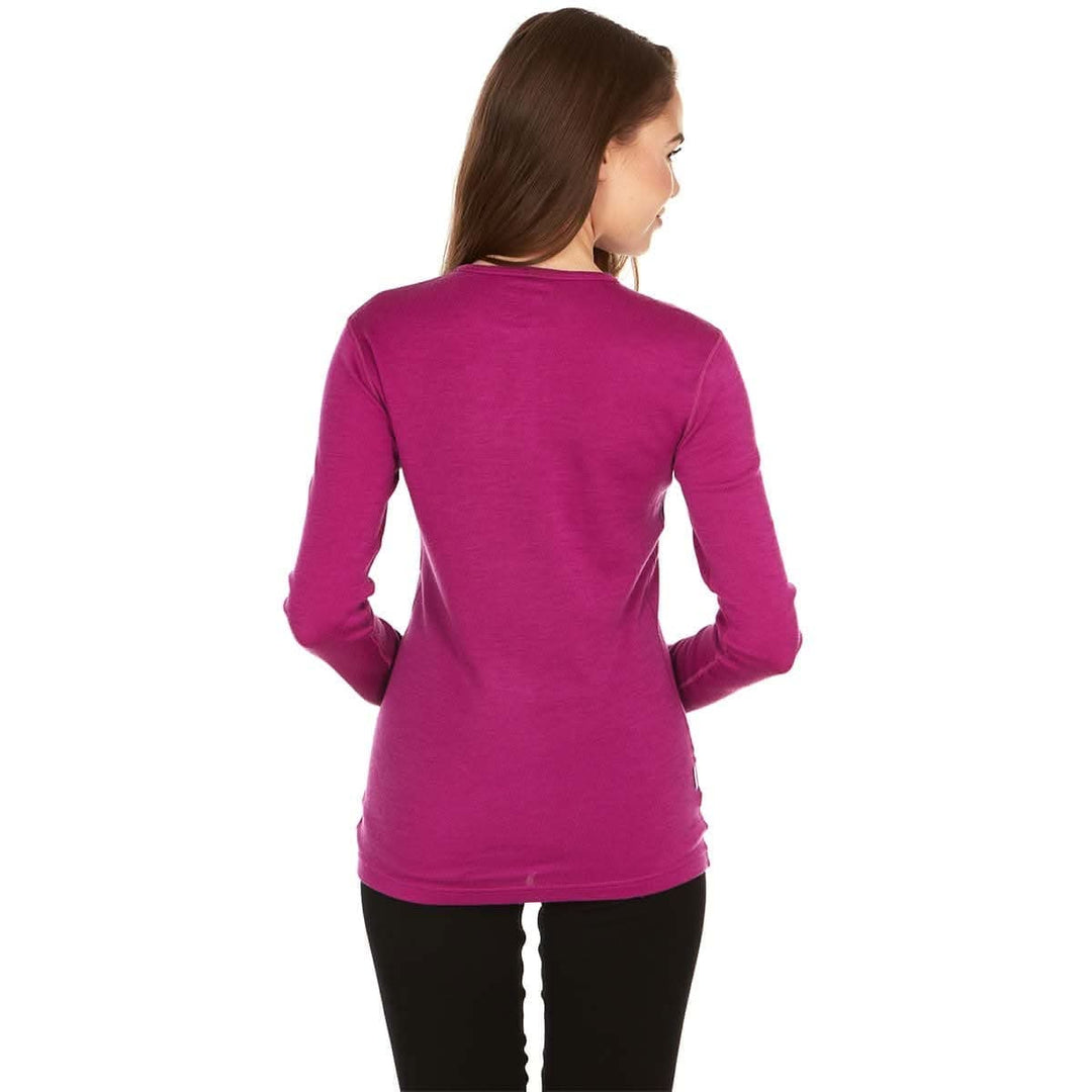 A woman models a soft, 100% merino wool, midweight base layer crew top. The women&