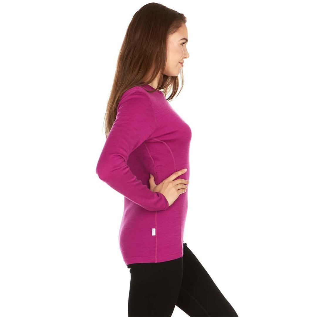 A woman models a soft, 100% merino wool, midweight base layer crew top. The women&