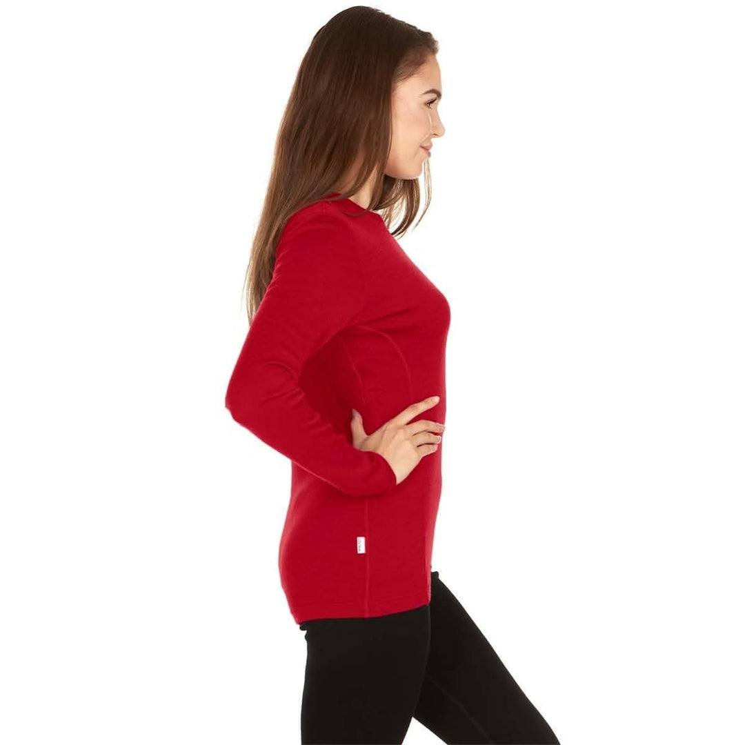 A woman models a soft, 100% merino wool, midweight base layer crew top. The women&