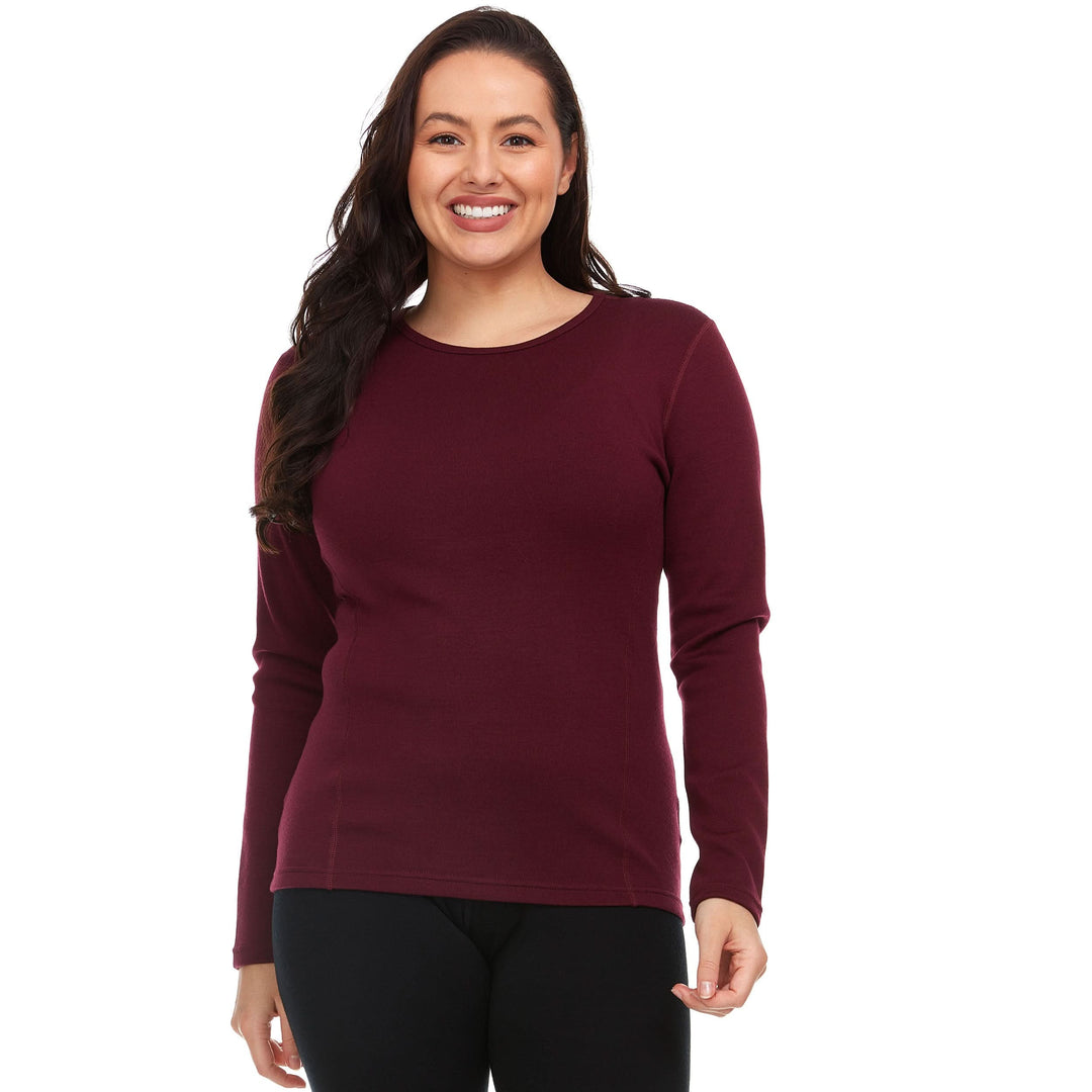A woman models the one hundred percent merino wool heavyweight women's base layer crew top. This super soft top has a princess cut style for a more flattering fit. Front view 1. #color_burgundy