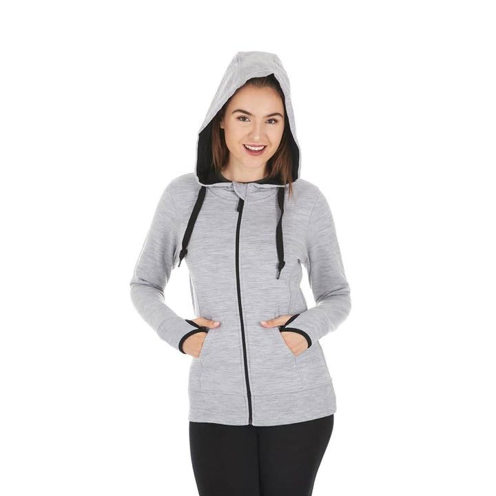 A woman models the heavyweight merino wool brushed fleece hoodie. The hoodie features a large hood with drawstrings, thumbholes, two pockets, and an interior stash pocket inside, front three-quarter view 