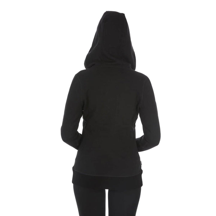 A woman models the heavyweight merino wool brushed fleece hoodie. The hoodie features a large hood with drawstrings, thumbholes, two pockets, and an interior stash pocket inside, back view 
