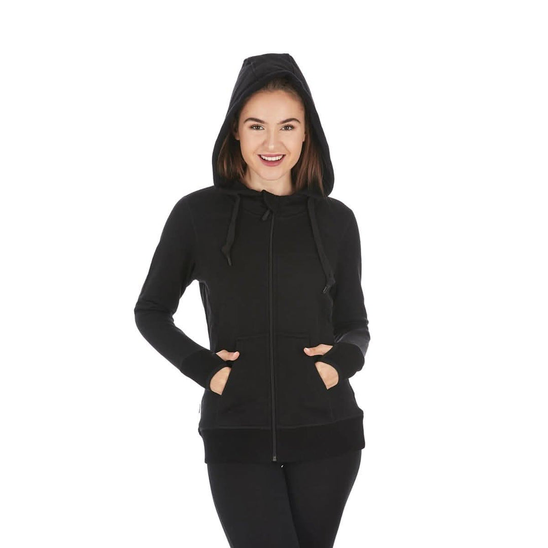 A woman models the heavyweight merino wool brushed fleece hoodie. The hoodie features a large hood with drawstrings, thumbholes, two pockets, and an interior stash pocket inside, front three-quarter view 