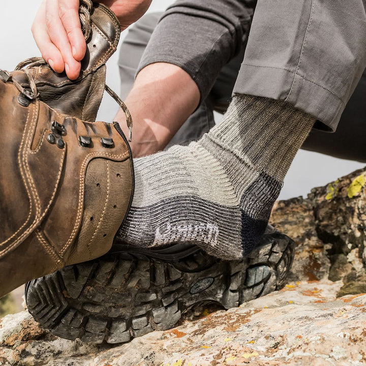 Midweight - Day Hiker Crew Socks - Minus33 Merino Wool Clothing, close-up of a gray socked foot sliding into a hiking boot