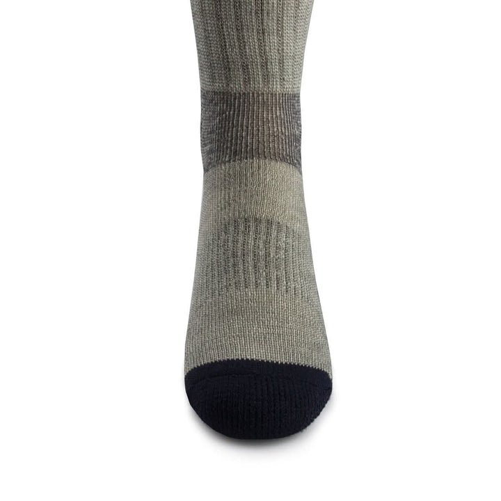 Front close-up view of a denim heather merino wool day-hiker sock on a foot form, highlighting the navy reinforced rounded toe, vertical ribbed ventilation panel over the forefoot, and dark gray fitted arch band 