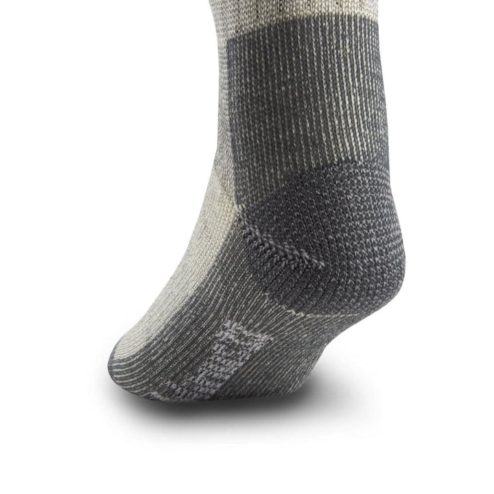 Side close-up view of a gray merino wool day-hiker sock on a foot form, highlighting the dark charcoal reinforced heel cup, ribbed ankle and arch support, and contrasting Minus33 logo near the forefoot 