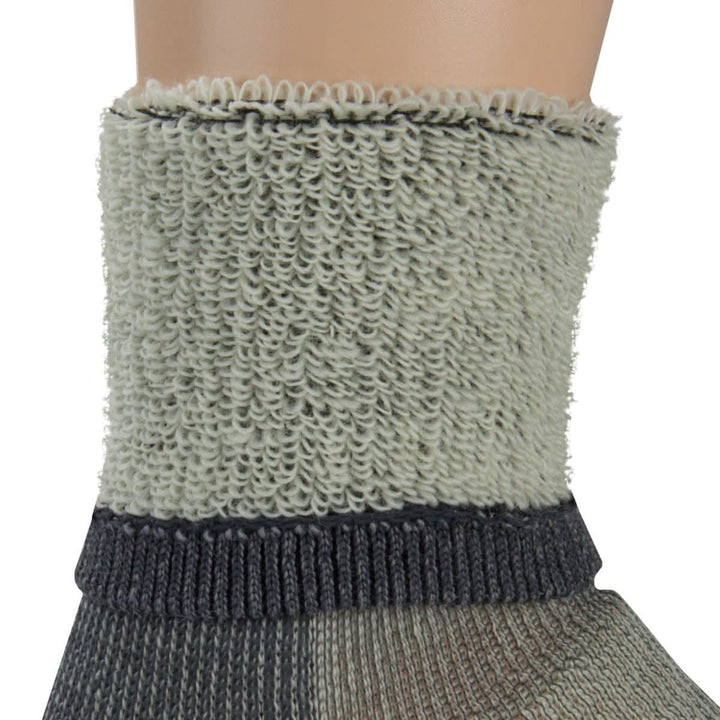 Macro inside-out view of a gray merino wool day-hiker sock cuff on a leg form, showing the dense looped terry lining above a dark gray ribbed support band and smooth knit lower section 