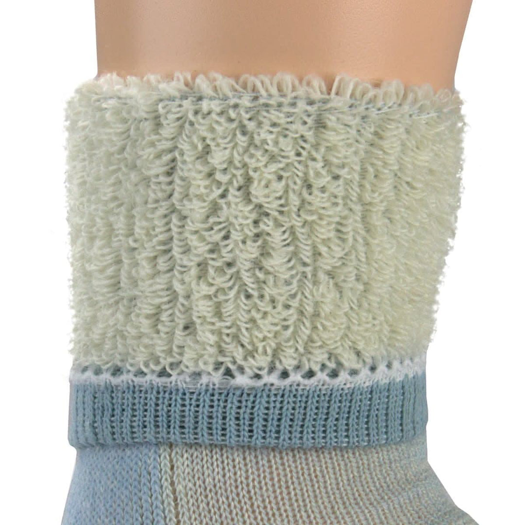 Macro inside-out view of a powder blue merino wool day-hiker sock cuff on a leg form, showing thick cream-colored looped terry cushioning above a powder blue ribbed support band and smooth lower knit 