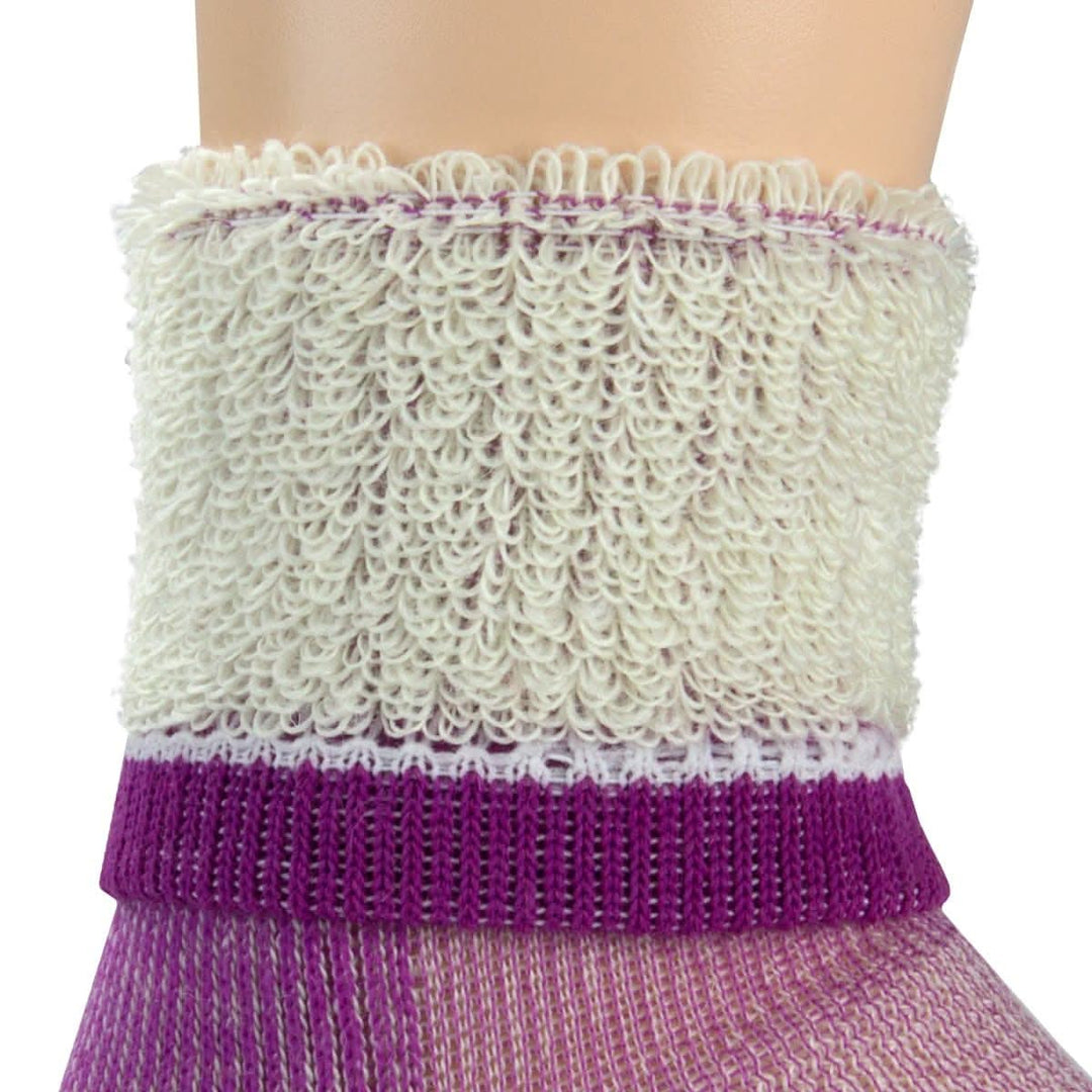 Macro inside-out view of a radiant violet merino wool day-hiker sock cuff on a leg form, showing thick cream looped terry cushioning above a vivid purple ribbed support band and lavender lower knit 