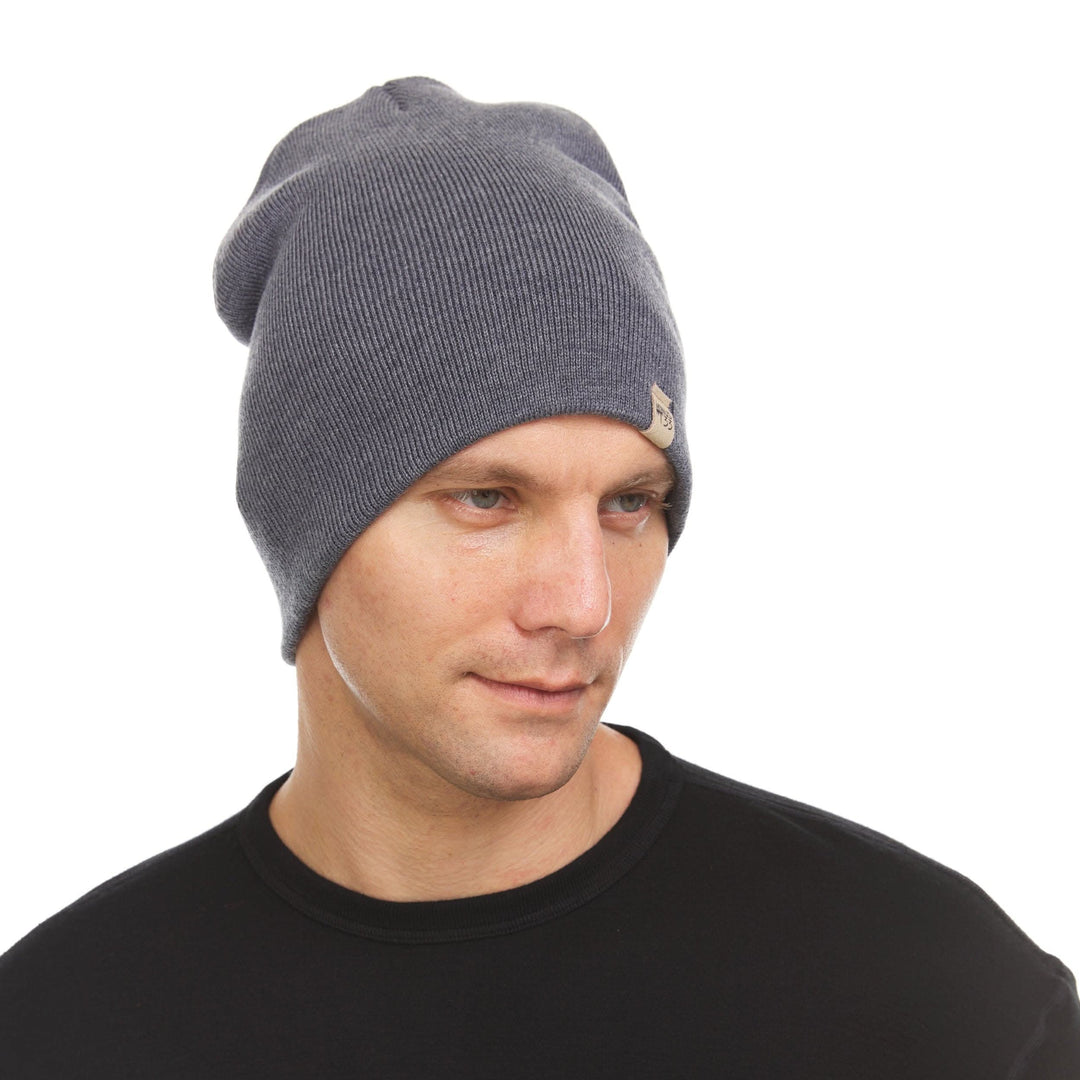 A man models a heavyweight, super soft, one hundred percent merino wool beanie. This heavyweight beanie is the warmest hat that we offer, perfect for hiking through the White Mountains, or sitting at a bonfire in January. 