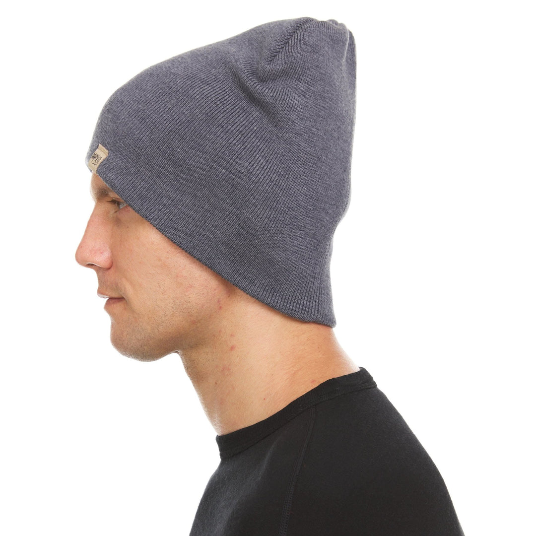 A man models a heavyweight, super soft, one hundred percent merino wool beanie. This heavyweight beanie is the warmest hat that we offer, perfect for hiking through the White Mountains, or sitting at a bonfire in January. 