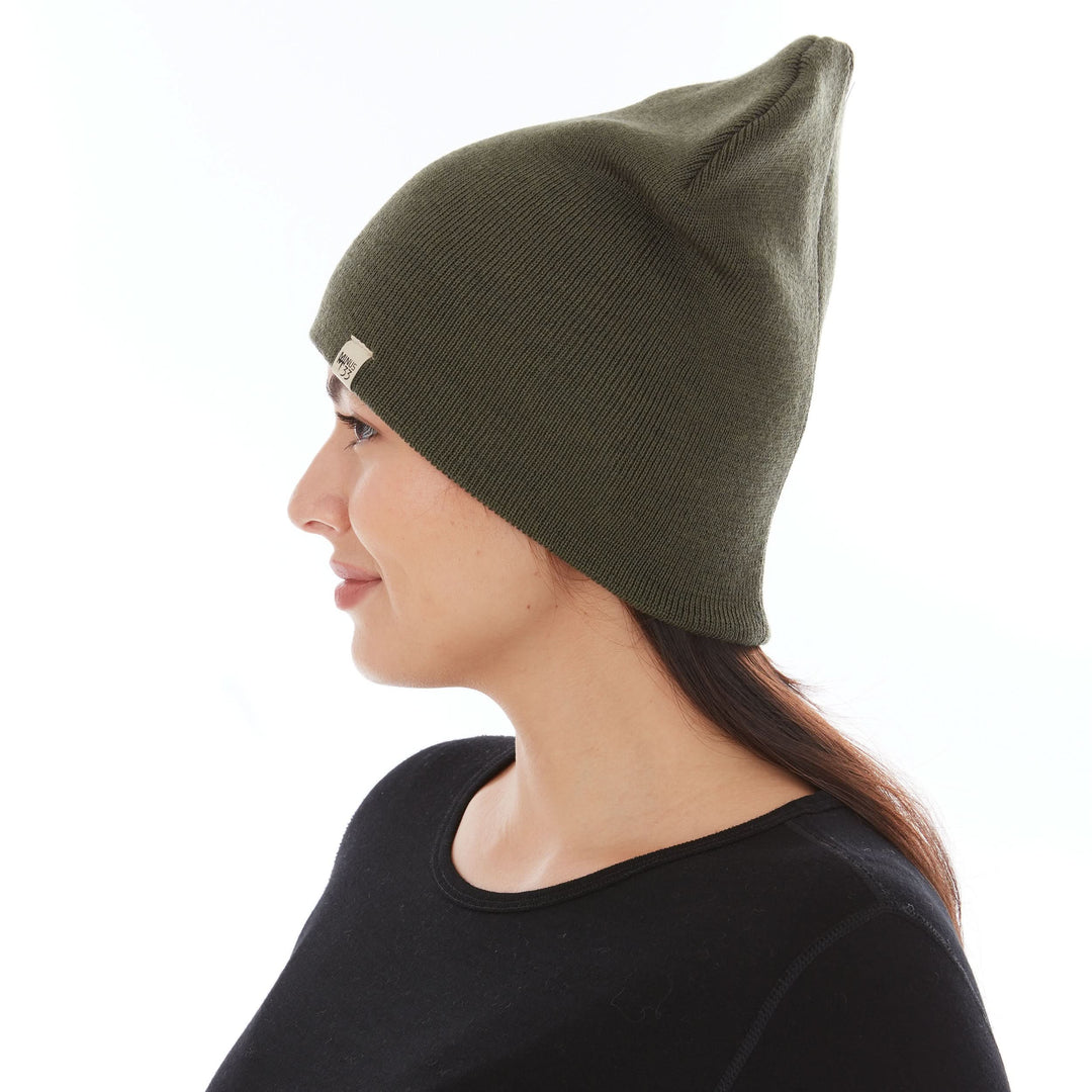A woman models a heavyweight, super soft, one hundred percent merino wool beanie. This heavyweight beanie is the warmest hat that we offer, perfect for hiking through the White Mountains, or sitting at a bonfire in January, right-facing side view 