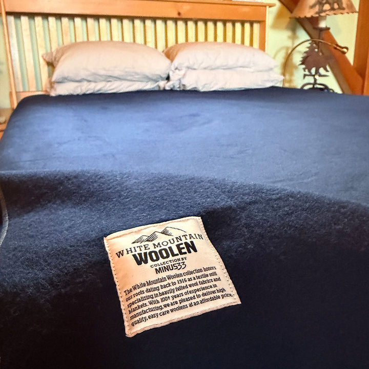 Blue blanket on a bed with a &