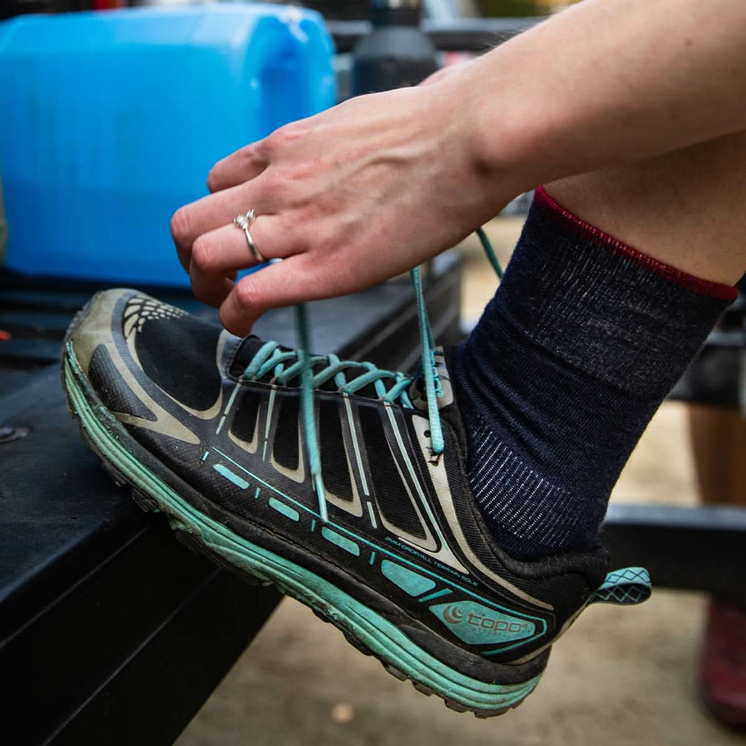 Side view of patriot-pattern micro weight merino wool full-cushion crew socks laid flat, showing striped cuffs, supportive ankle panels, cushioned soles, reinforced heels, and toes 
