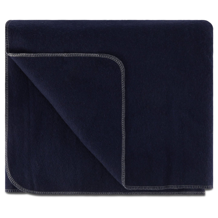 Front view of a folded navy lodge wool blanket with the upper-left layer turned diagonally inward, clearly showing the matching reverse side and light decorative stitching around the rounded edge 