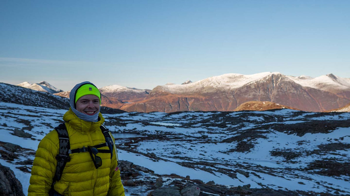 man hiking in the snow wearing merino wool beanie and multiclava balaclava