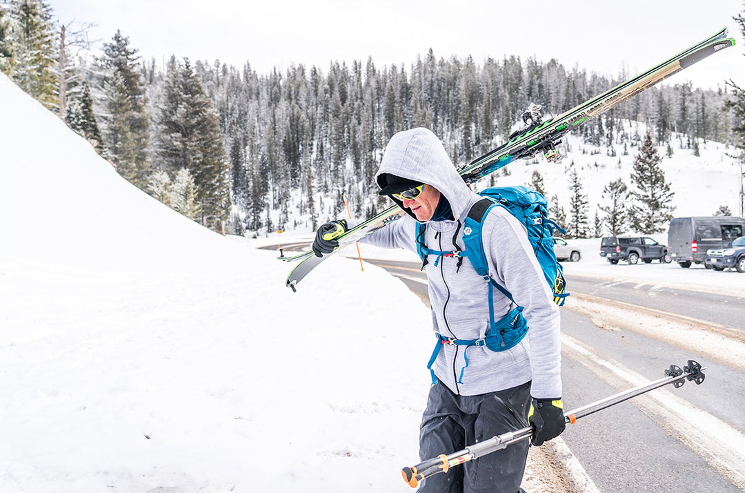 Lifestyle view of a skier wearing a merino wool hoodie