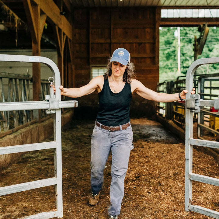 Women opens bar gate wearing lightweight wool tank top 
