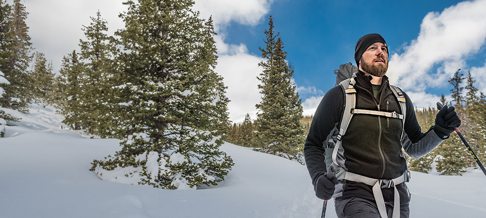 man snowshoeing wearing midweight woolverino full zip