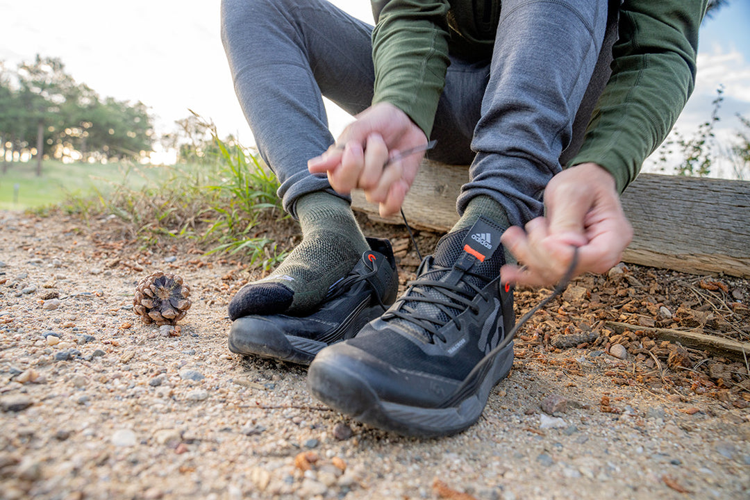 man tying his sneakers wearing mountain heritage socks and midweight woolverino running flyless tights