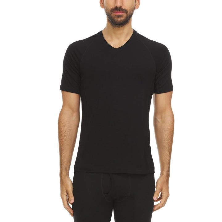 Front view of a male model wearing a fitted black lightweight Woolverino merino wool short-sleeve V-neck shirt and black base-layer bottoms 