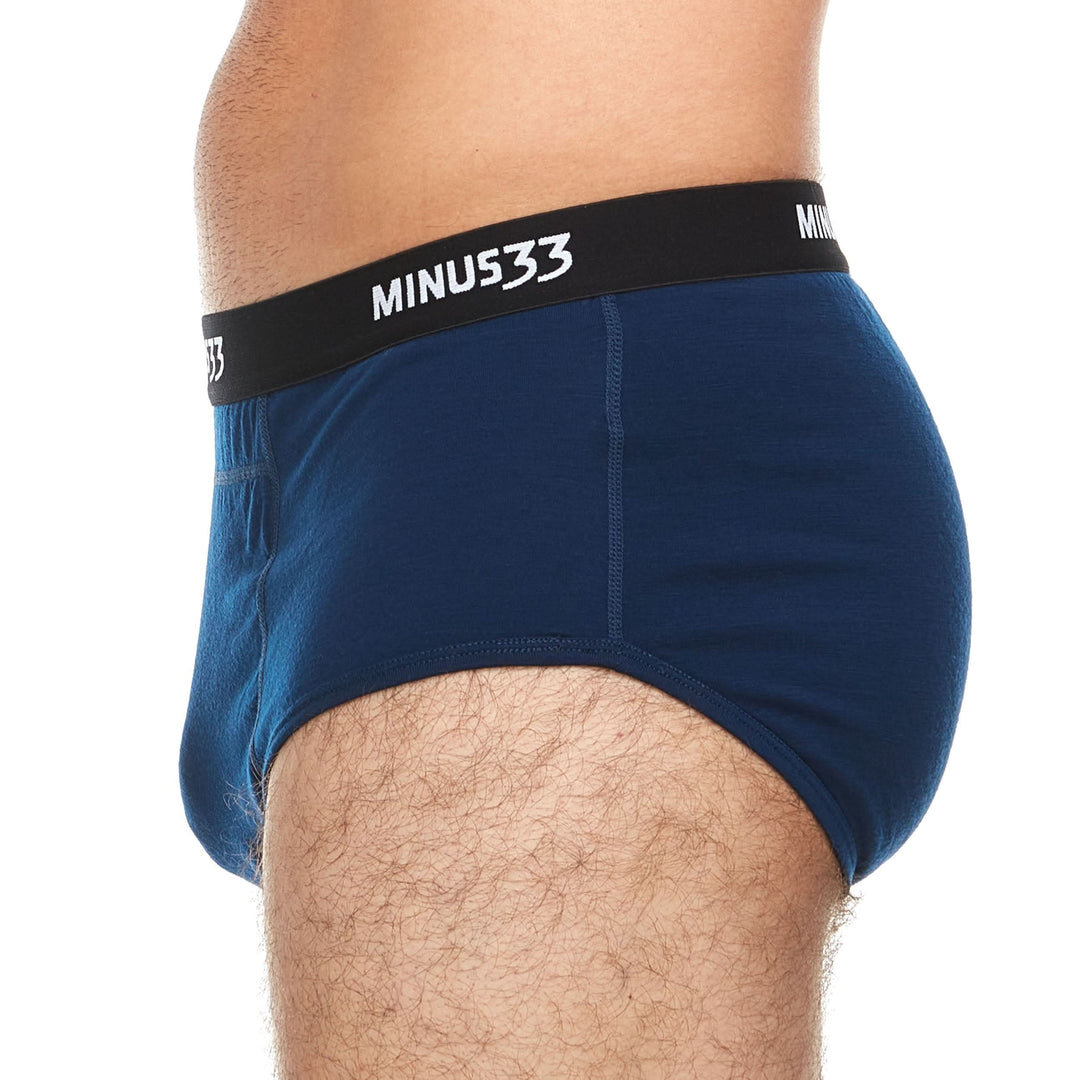 Front view from waist to upper thighs of a man wearing navy Woolverino micro weight merino wool boxer briefs, showing the wide waistband, contoured front pouch, fitted legs, and flat seams 