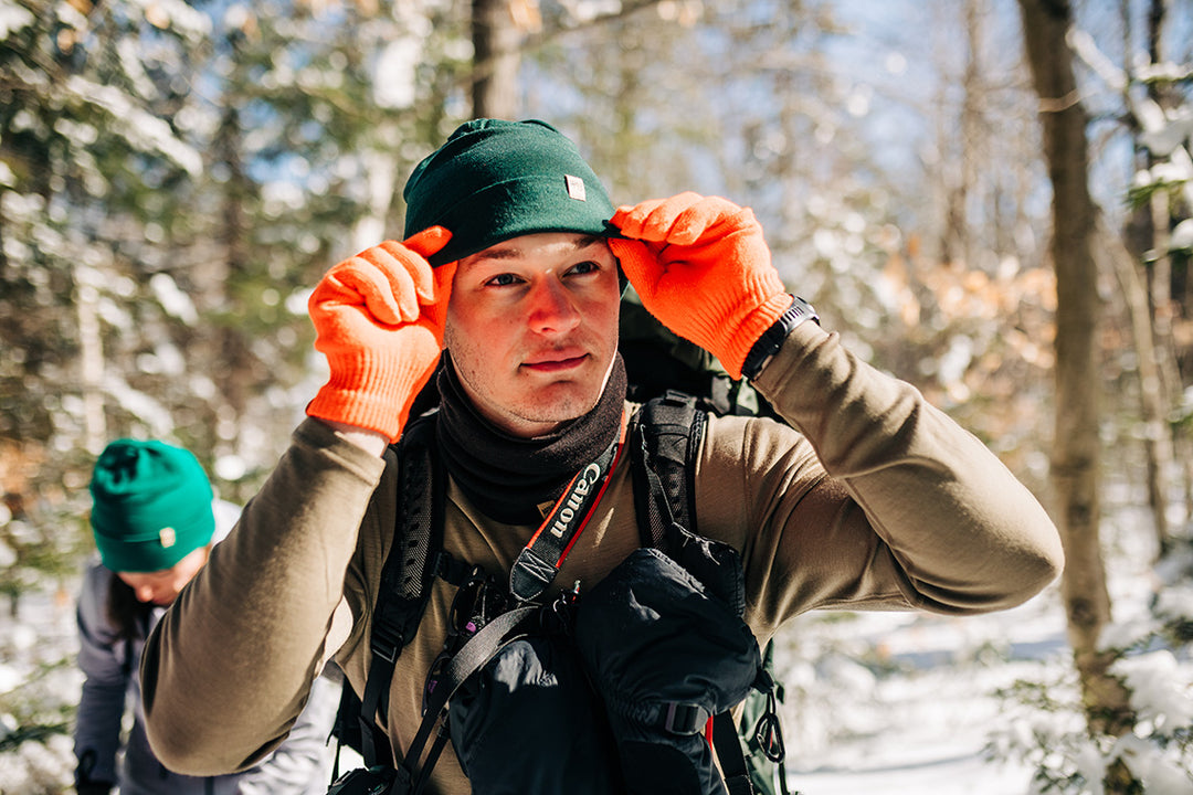 man hiking in the winter wearing midweight base layers
