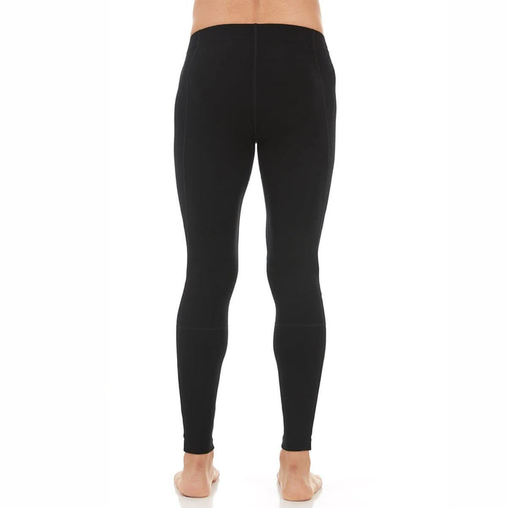 Back close-up from waist to knees of a man wearing black Woolverino midweight merino wool flyless running tights, showing the wide waistband, smooth rear panel, center seam, and fitted legs 