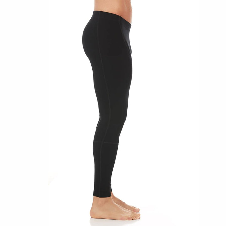 Left side close-up from waist to knees of a man wearing black Woolverino midweight merino wool flyless running tights, showing the wide waistband, smooth side panel, flatlock seams, and fitted legs 
