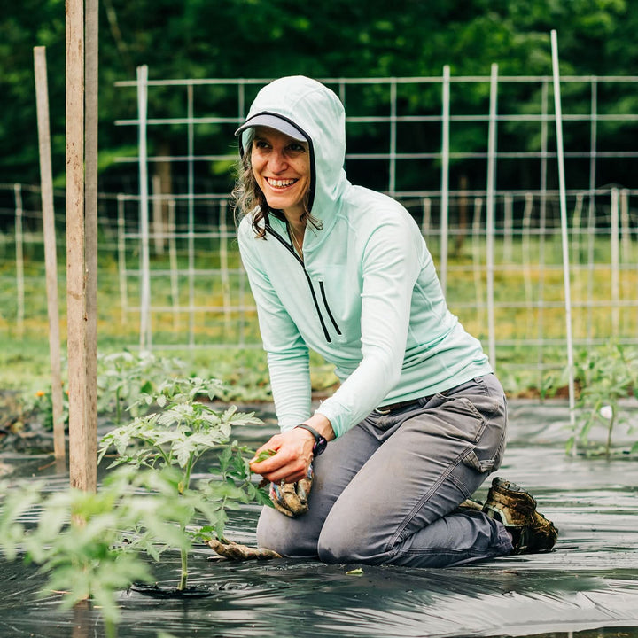 Woman gardening wearing a microweight Merino wool sun hoodie  
