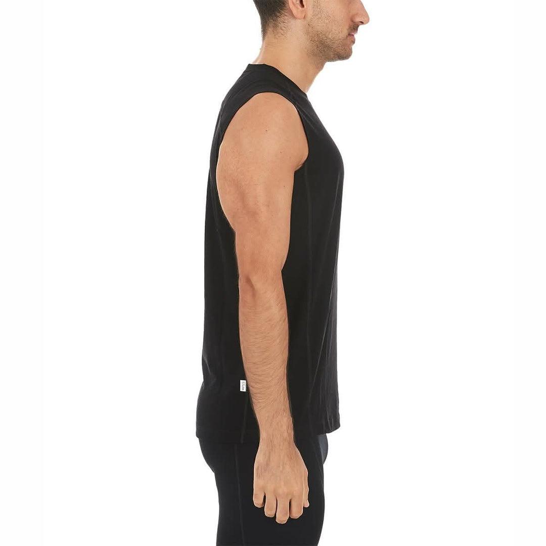 Close-up front view of a man wearing a black Woolverino micro weight merino wool sleeveless crew-neck top, showing the round neckline, broad shoulder panels, sleeveless armholes, and fitted torso 