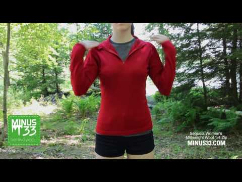A woman models the hundred percent merino wool midweight quarter zip sweater in a demonstrational video 